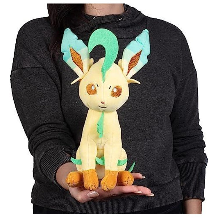 Peluche Folipurba 20 cm posée à côté d’un livre pour illustrer sa taille et son volume.